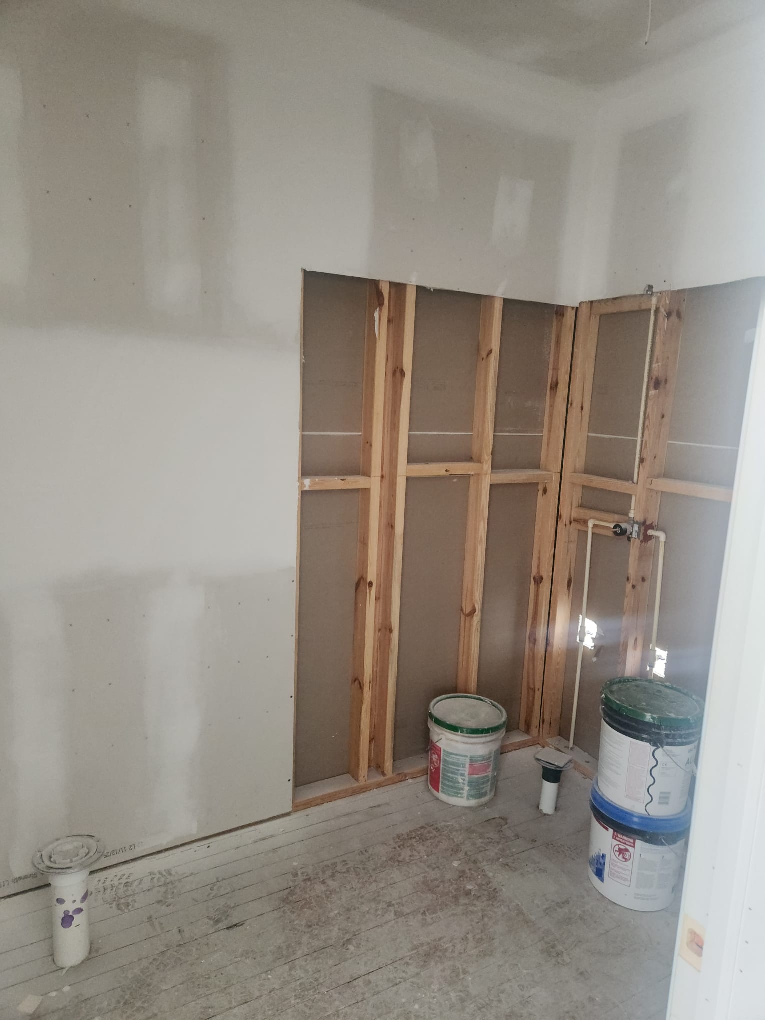 Bathroom rough-in with plumbing stub-outs and drywall
